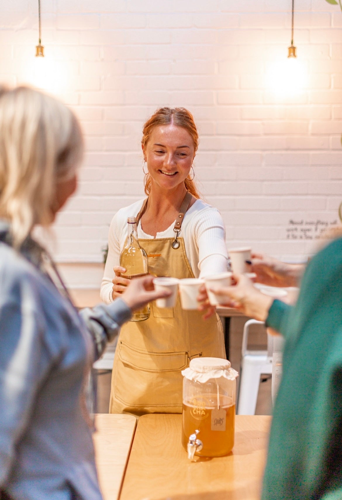 Our founder Hebe "cheersing" with glasses with students from a kombucha workshop, happy smiling faces - boochacha